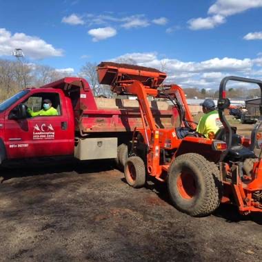 Loader filling a truck with bulk mulch for delivery
